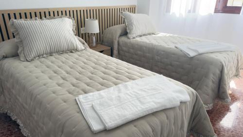 a bedroom with two beds with white sheets at Puerta del Mar 2 in Adra