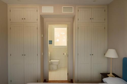 a bathroom with a toilet and a window at Siete Villas Olivencia Natural in Agua Amarga
