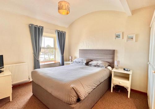 a bedroom with a large bed and a window at Seacrest Cottage in Conwy