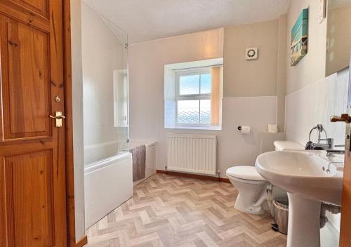 a bathroom with a toilet and a sink and a tub at Seacrest Cottage in Conwy