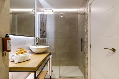 a bathroom with a sink and a shower at Petit Palace Plaza de la Reina in Valencia