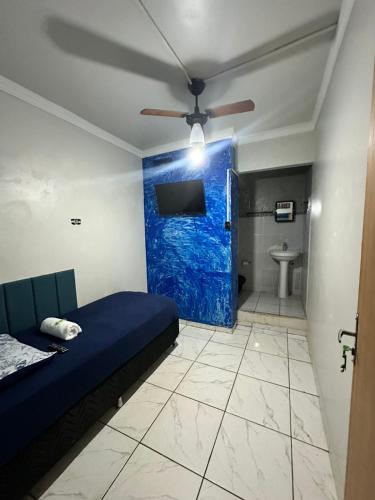 a room with a bed and a blue wall at Pousada Amizade in Foz do Iguaçu
