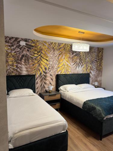 two beds in a bedroom with a wall mural at Pansion Afitos in Laktaši