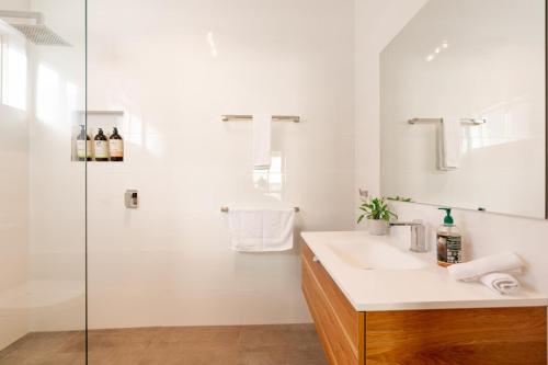 a white bathroom with a sink and a shower at Comfort & Quiet 3BR, CBD 5mins in Kennington