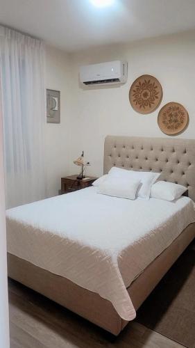 a bedroom with a large bed with white sheets and pillows at El descanso in Higuey