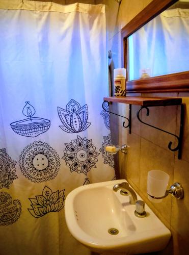 a bathroom with a sink and a shower curtain at Cabañas Rowal Potrerillos in Potrerillos
