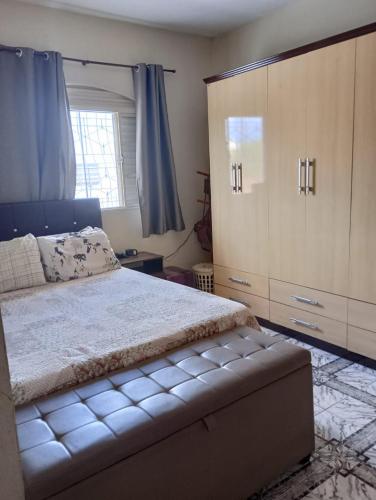 a bedroom with a bed and a large cabinet at Nossa Senhora Aparecida Apartment in Cachoeira Paulista