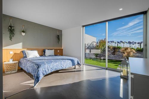 a bedroom with a bed and a large window at "Villa Carpe Diem" Country house in Cambarinho