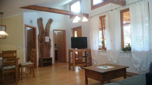 a living room with a tv and a table at Biohof - Familie Neuberger in Pöttelsdorf