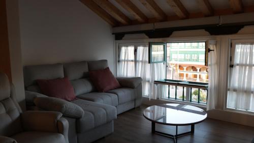 a living room with a couch and a glass table at Almagro Plaza Apartamento in Almagro