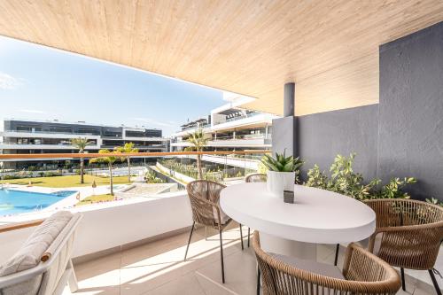 an apartment with a balcony with a table and chairs at CasaBlanka Premium Apartment with Pool & Wellness in Torrevieja