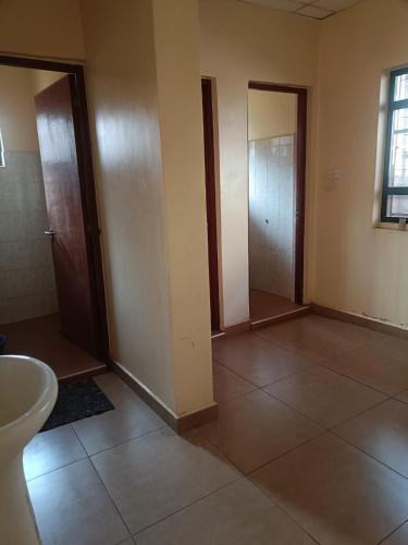 an empty room with two doors and a sink at Hacienda Villa in Juja