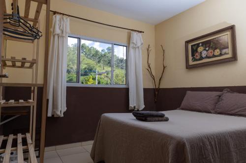 a bedroom with a bed and a window at Oca Delfim in Delfim Moreira