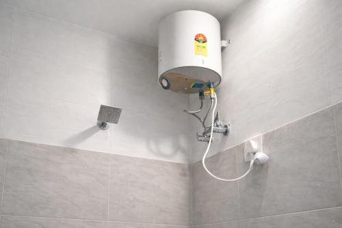 a shower in a bathroom with a water tank at Pushp Vatika Hotel & Resort in Thālera