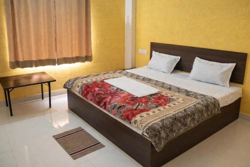 a bedroom with a large bed with a blanket at Pushp Vatika Hotel & Resort in Thālera
