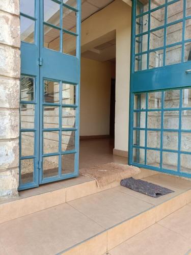 an empty room with a blue door and a mat at Hacienda Villa in Juja