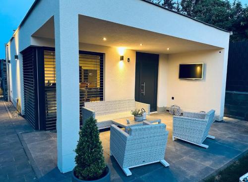 a patio with two chairs and a television on a house at Apartment Timeout in Welschbillig