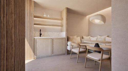 a dining room with a table and white chairs at Pefkos Beach Studios & Apartments in Pefki