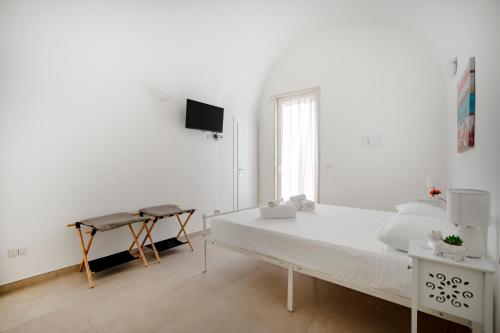 a white room with a bed and a tv at Ranieri rooms & relax stella in Mola di Bari