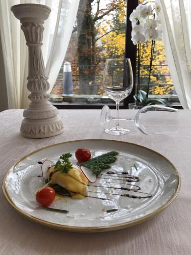 a plate of food on a table with a wine glass at Hotel Boutique Belvedere in Sinaia