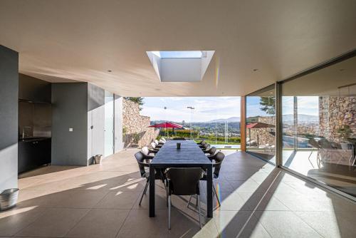 a dining room with a table and some glass walls at "Villa Carpe Diem" Country house in Cambarinho