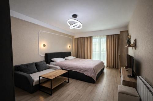 a hotel room with a bed and a couch at Relax Apartments in Crystal Residence Bakuriani in Bakuriani