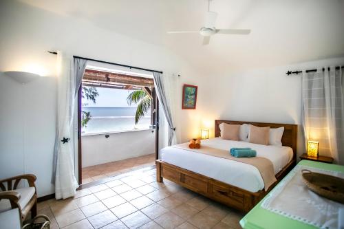 a bedroom with a bed and a view of the ocean at Beach, Blue Sea, Sunset and Private Pool in Rivière Noire