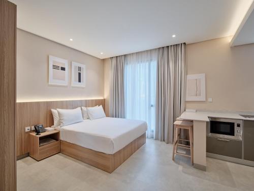 a hotel room with a bed and a desk at The Code Residence - ذا كود ريزيدنس in Kuwait