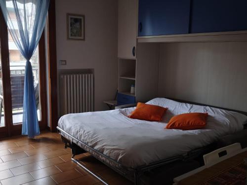 a bedroom with a bed with two orange pillows on it at Novate Fiera in Novate Milanese