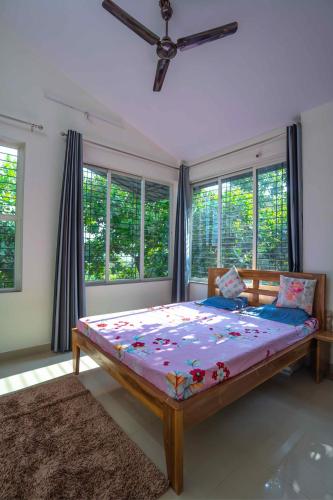 a bedroom with a large bed in a room with windows at Swara Villa Your Perfect Getaway in Jāmb
