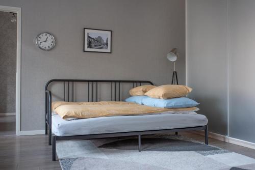 a bed with two pillows and a clock on the wall at Diana Park Apartments in Helsinki
