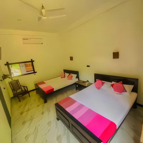 a room with two beds and a chair in it at Green Haven Yala Safari Retreat in Tissamaharama