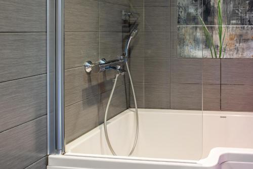 a shower with a glass door next to a sink at Diana Park Apartments in Helsinki