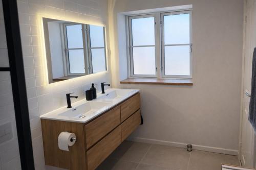 a bathroom with a sink and two windows at Solhjem Bornholm - Top Rated Sea View Stay in Gudhjem