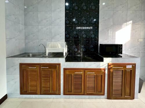 a kitchen with a sink and a microwave at Cocoon Casa in Hat Yai