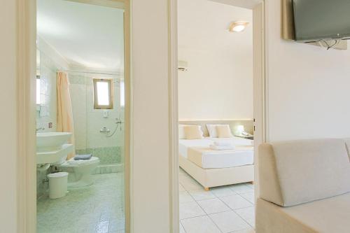a bedroom with a bed and a bathroom with a tub at Elmi Beach Hotel & Suites in Hersonissos