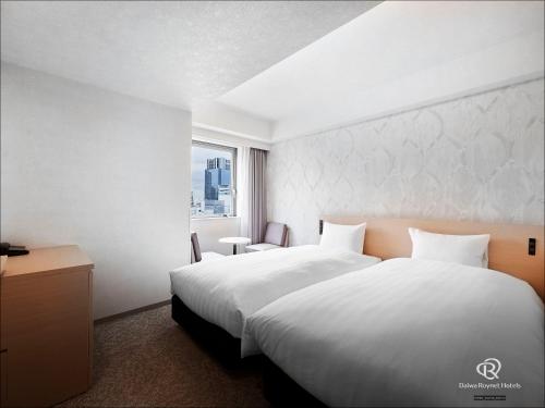 a hotel room with a large bed and a window at Daiwa Roynet Hotel Kawasaki in Kawasaki