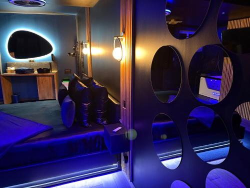 a room with a purple room with a bed and lights at Suite Casanova avec SPA & Escape Love Game - Doux Bleu Jeux in Niort