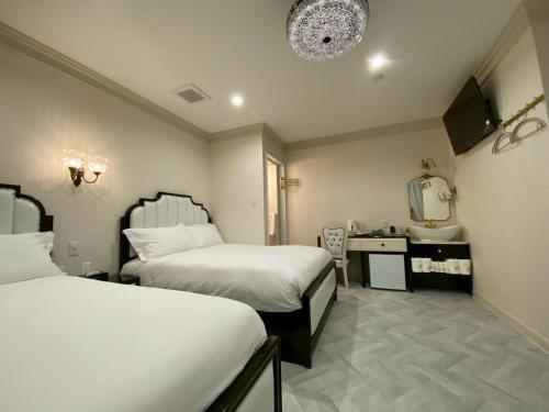 a hotel room with two beds and a sink at 大同GardenHotel 大阪西九条Annex in Osaka