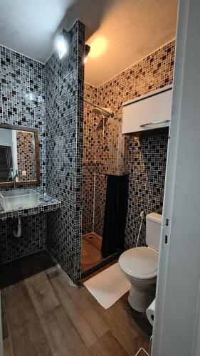 a bathroom with a toilet and a sink and a shower at Casa Caminho do Meio in Rio de Janeiro