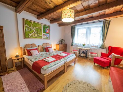 a bedroom with a bed and a red chair at A MI KISHÁZUNK vendégház in Szomód