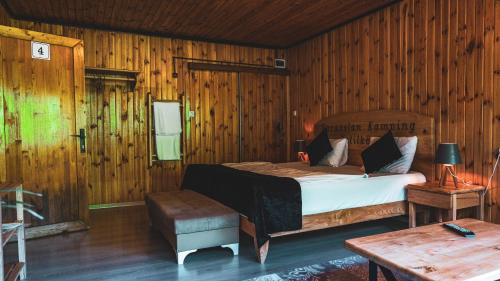 a bedroom with a bed and a wooden wall at Karaaslan Kamping Tesisleri in Kazandere