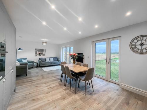 a dining room with a table and chairs and a living room at Eriska View in Port Appin