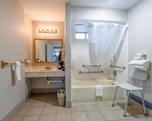 a bathroom with a tub and a sink and a shower at Days Inn by Wyndham Burns in Burns
