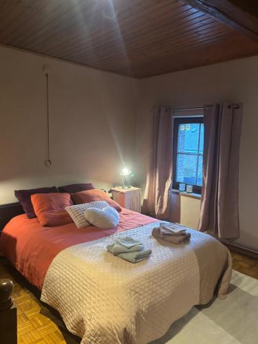 a bedroom with a bed with two towels on it at La Petite maison in Montleban