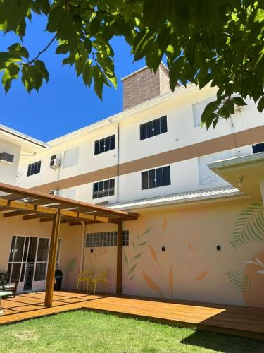 a large white building with a patio and grass at Residencial Marilis in Palhoça