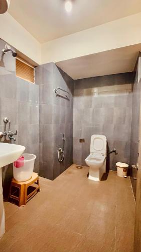 a bathroom with a toilet and a sink at Hotel Marvel International And Restaurant in Darjeeling