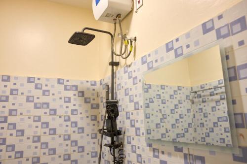 a bathroom with a shower with blue and white tiles at Oasis Guesthouse Juba in Juba