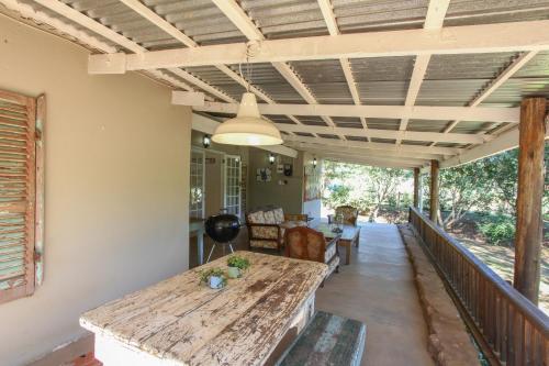 eine Veranda mit einem Holztisch und einer Decke in der Unterkunft Lavender Trout Guest Farm in Nottingham Road