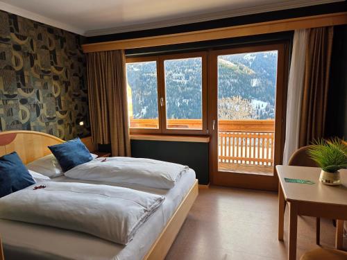 a hotel room with a bed and a large window at Hotel Restaurant Raunig in Bad Kleinkirchheim